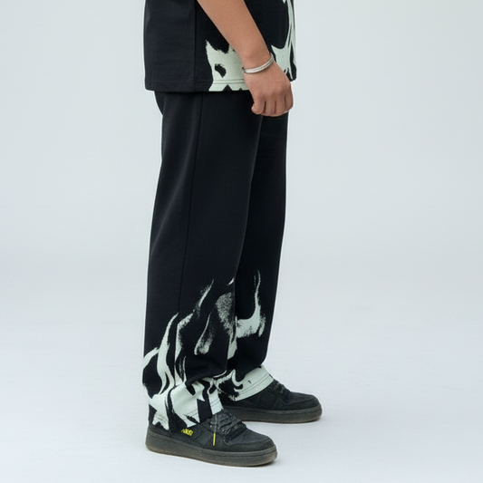 Person wearing black pants with white abstract designs on a white background