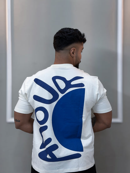 Person wearing amour t shirt with a blue logo on the back, standing against a plain background.
