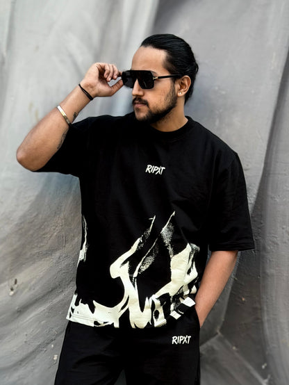 Man wearing a black t-shirt with white graphics and 'Ripxt' branding against a gray background