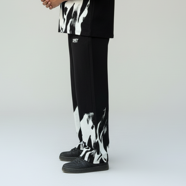 Black pants with white abstract patterns worn by a person on a light gray background